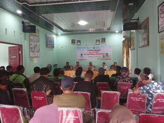 Petugas Polres Bengkalis berdiri di area perkebunan sawit sambil berkoordinasi dengan warga terkait sengketa lahan HGU PT TKWL.