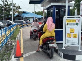 Pengendara motor antre membeli tiket di Pos E-Tiket Pelabuhan RoRo Air Putih–Sungai Selari, Bengkalis, Riau,
