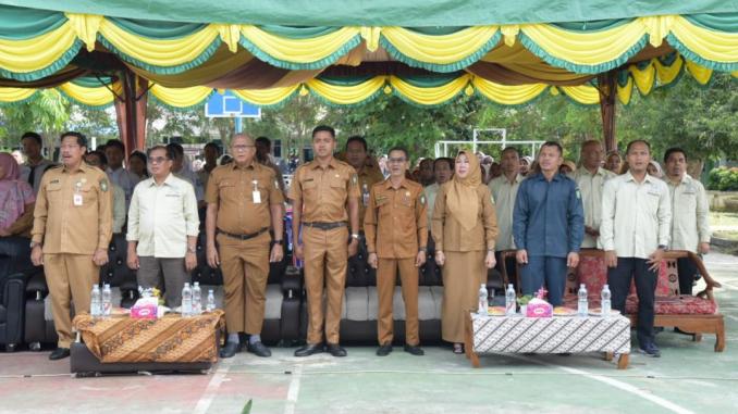 IMG-20251006-WA0004 Pejabat Pemkab Bengkalis berdiri di bawah tenda berwarna hijau-kuning saat pembukaan Gebyar Fisika ke-18 di SMAN 2 Bengkalis.