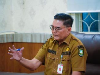 Kepala Diskominfotik Bengkalis, Suwarto, menjelaskan program promosi digital gratis untuk pelaku UMKM di ruang kerjanya.
