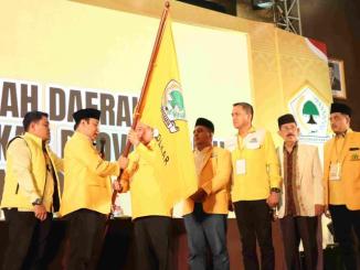 Yulisman menerima bendera Partai Golkar dari perwakilan DPP dalam Musda XI Golkar Riau di Pekanbaru, Sabtu, 8 November 2025.