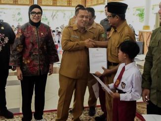 Simbolisasi penyaluran beasiswa PIP jalur aspirasi DPR RI oleh Hj. Dewi Juliani.