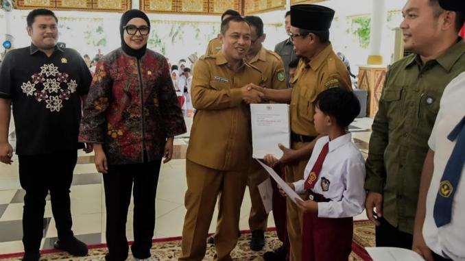 Simbolisasi penyaluran beasiswa PIP jalur aspirasi DPR RI oleh Hj. Dewi Juliani.