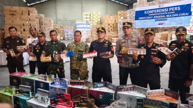 Petugas Bea Cukai berdiri di depan tumpukan rokok ilegal hasil penyitaan di Pekanbaru.
