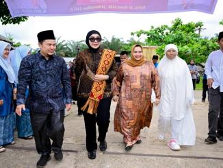 Kasmarni dan Dewi Juliani menyerahkan bantuan sembako kepada masyarakat di Desa Muara Basung, Bengkalis.