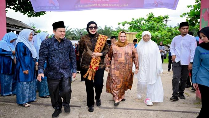 Kasmarni dan Dewi Juliani menyerahkan bantuan sembako kepada masyarakat di Desa Muara Basung, Bengkalis.