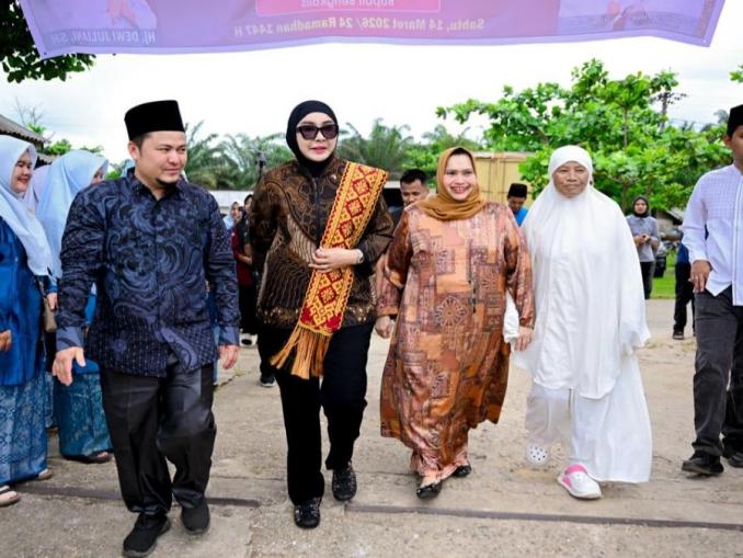 Kasmarni dan Dewi Juliani menyerahkan bantuan sembako kepada masyarakat di Desa Muara Basung, Bengkalis.