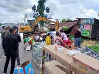 Petugas membongkar bangunan liar di kawasan Siak IV Pekanbaru menggunakan alat berat.