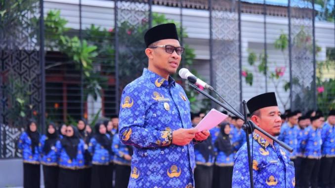 Pemkab Bengkalis menyerahkan penghargaan kepada guru dan sekolah berprestasi dalam apel Hardiknas 2026.